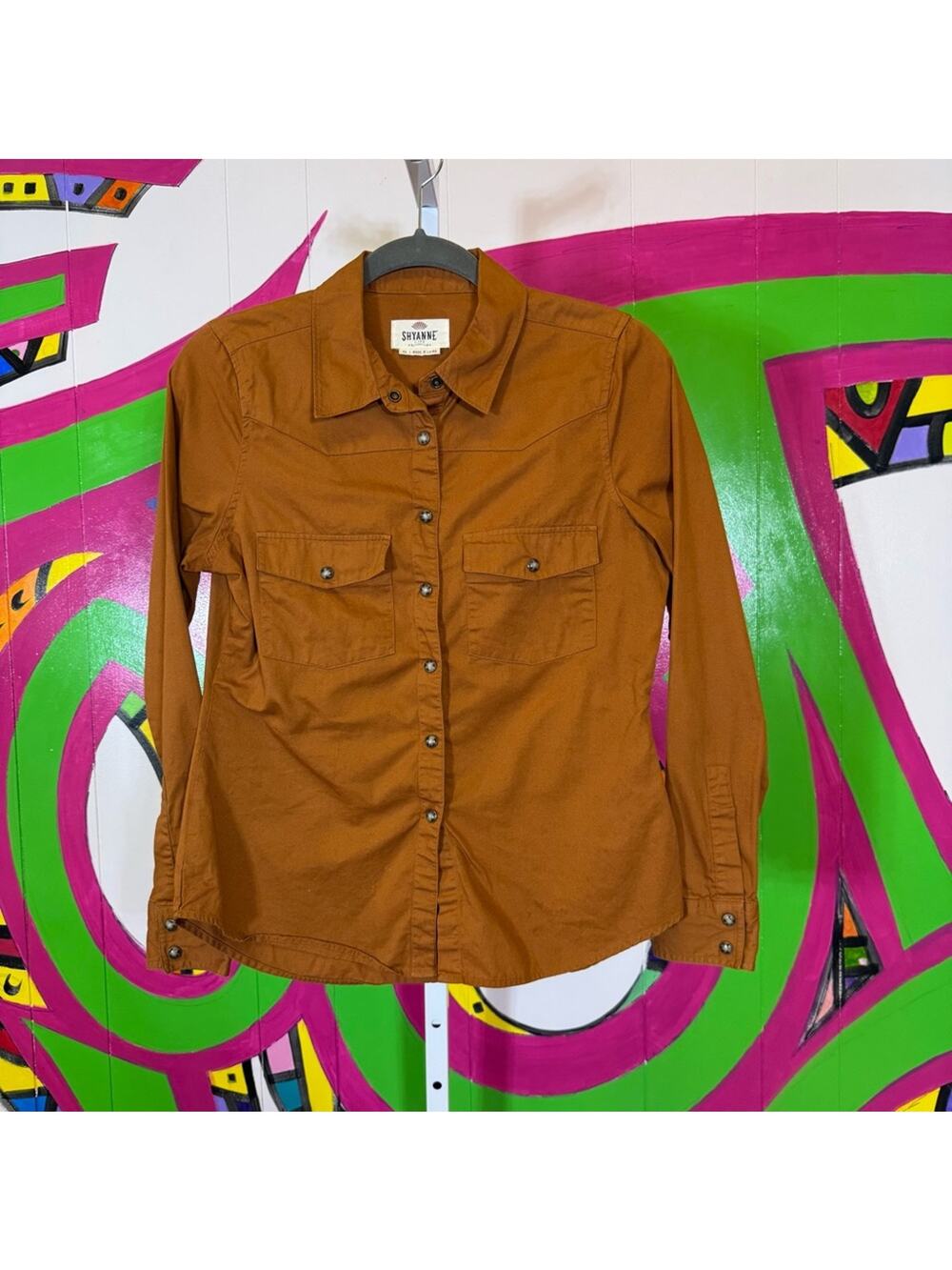 Shyanne, Brown Pearl Snap Top. Size XS. Minor staining on the front as shown.